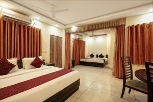 新德里Airport Hotel IVY的一间卧室配有两张床、一张桌子和一张书桌