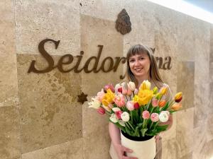 索斯诺夫卡Hotel Seidorf w Sosnówce koło Karpacza的手指前拿着花束的女人