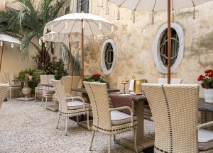 威尼斯Palazzo Paruta & Wellness Suites的一间带桌椅和遮阳伞的餐厅