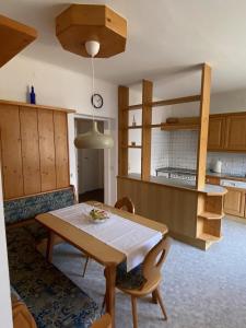格吕瑙Almufer-Appartements的厨房以及带桌椅的用餐室。