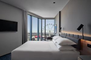 墨尔本Vibe Hotel Melbourne Docklands的酒店客房设有一张大床和一个大型轮子
