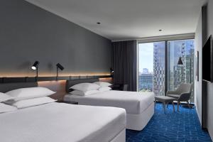 墨尔本Vibe Hotel Melbourne Docklands的酒店客房设有两张床和大窗户。