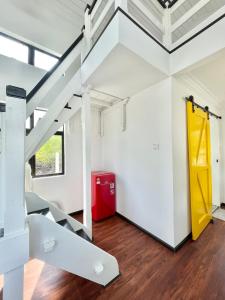 士兆Tiny House & Pool 4 pax 3 mins Merang Jetty的客房设有楼梯和红色冰箱
