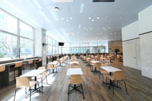 昌原市Toyoko Inn Changwon的一间设有桌椅和窗户的自助餐厅