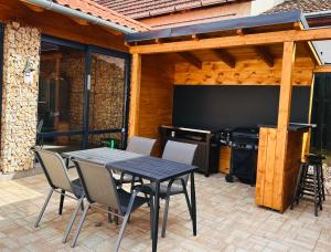 KerekiBikeaway Guesthouse的庭院配有桌椅和大屏幕电视。