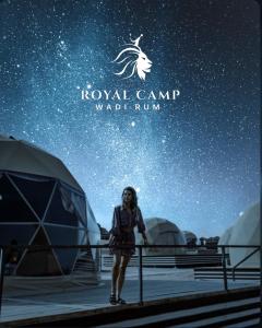 瓦迪拉姆ROYAl WADI RUM CAMP的站在星空下帐篷前的女人