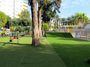科米索Trinacria House - Appartamento Deluxe Comiso的一座公园,公园里有一棵树和一个游乐场
