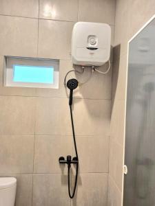 棉兰Zizi Homey Cemara Asri Triple Room的浴室设有淋浴,墙上配有摄像头