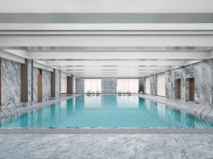 乌鲁木齐乌鲁木齐康莱德酒店的大楼内一个蓝色的大型游泳池