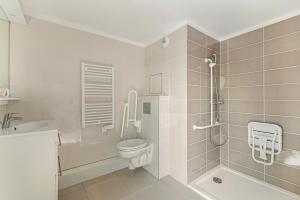 普瓦西OVELIA Poissy - Les Romantiques的白色的浴室设有卫生间和水槽。