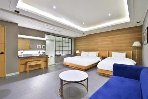 釜山Seomyeon IB Hotel的酒店客房,设有两张床和一张沙发