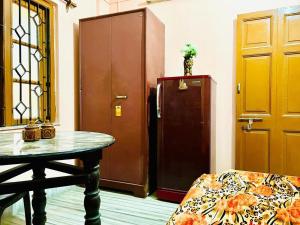 kolkataAntique Spacious Apartment with kitchen, AC and furniture的客房设有桌子和冰箱。