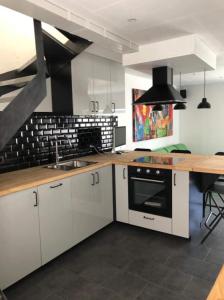 希迈Froissart Loft的厨房配有白色橱柜和木制台面