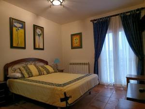 ValdecuencaLA POSADA DEL HORNO的一间卧室设有一张床和一个大窗户