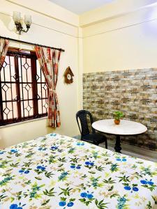 kolkataAntique Spacious Apartment with kitchen, AC and furniture的一间卧室配有一张床、一张桌子和一个窗户。