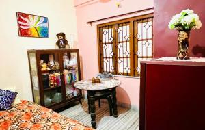 kolkataAntique Spacious Apartment with kitchen, AC and furniture的客房设有桌子、床和窗户。