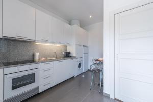 加亚新城GuestReady - Spacious modern stay in Porto的厨房配有白色橱柜和炉灶烤箱。