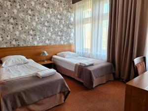 库特诺Hotel Restauracja Rondo的配有窗户的酒店客房内的两张床