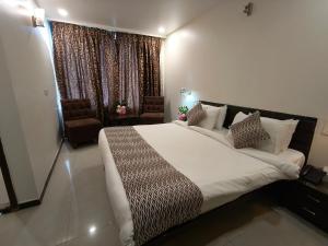 那格浦尔Hotel Heritage 2001, Nagpur的一间卧室设有一张大床和一个窗户。