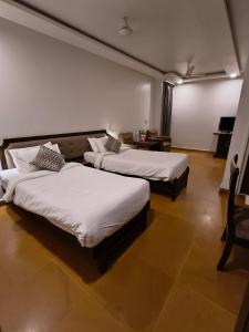 那格浦尔Hotel Heritage 2001, Nagpur的一间客房配有两张床和一张沙发