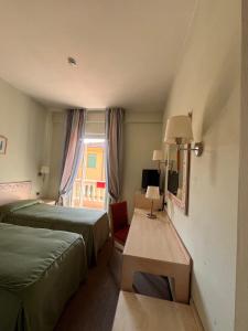 加尔法尼亚纳新堡HOTEL LUDOVICO ARIOSTO的酒店客房设有两张床和窗户。