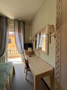 加尔法尼亚纳新堡HOTEL LUDOVICO ARIOSTO的一间卧室配有一张带镜子的桌子和一张床