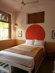 QuerimAdi Shakti Guesthouse的一间卧室配有一张大床和红色床头板