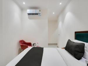 新德里HOTEL IVORY INN NEW DELHI At IGI AIRPORT的卧室配有白色的床和红色椅子
