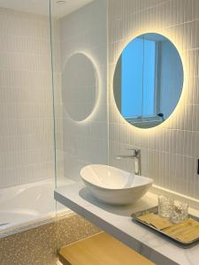 香港Urbanwood Hung Hom的一间带水槽、浴缸和镜子的浴室
