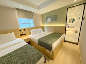 香港Urbanwood Hung Hom的酒店客房设有两张床和窗户。