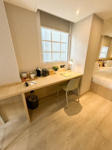 香港Urbanwood Hung Hom的客房设有一张桌子、一张床和一个窗户。