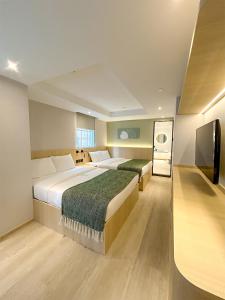 香港Urbanwood Hung Hom的酒店客房设有两张床和一台平面电视。