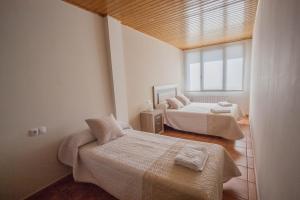 GúdarApartamentos Mirador的一间卧室设有两张床和窗户。