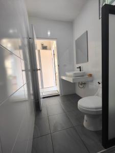 素叻ริมธารริเวอร์เพลส的白色的浴室设有卫生间和水槽。
