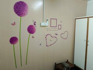 乔治市seaview hostel的墙上有紫色鲜花的房间,配有镜子