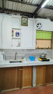 乔治市seaview hostel的厨房配有白色橱柜和水槽