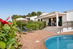 苏昂博Villas Menorca Sur的一个带游泳池和房子的后院