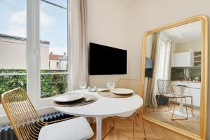 布洛涅-比扬古Suite Deluxe 2 by Les Maisons de Charloc Homes的一间设有白色桌子和镜子的用餐室
