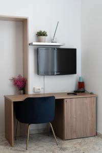 特拉尼B&B Longobardi的一张桌子,墙上有一台电视,椅子