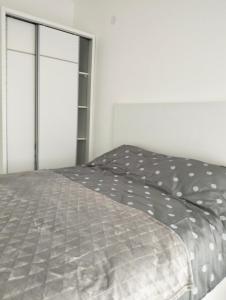 蒂瓦特Tivat Apartman的卧室配有带灰色棉被的床