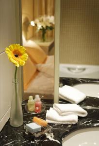 香港香港丽悦酒店的浴室水槽上的一个黄色花瓶