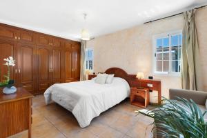 圣米格尔德阿沃纳Villa Golf del Sur的卧室配有一张白色的大床和一张沙发。