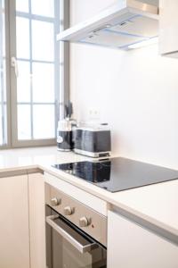 布鲁塞尔THE GOOD FLATS的厨房配有白色橱柜和炉灶烤箱。