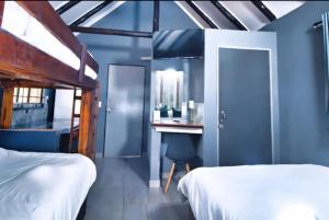 内尔斯普雷特Ndalo Lodge Mbombela的一间卧室配有两张床和一张带镜子的书桌