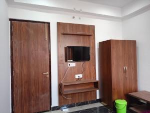 AyodhyaDAYA RESORT的客房设有木制橱柜和平面电视。