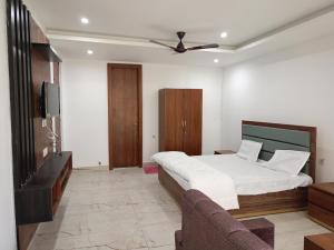 AyodhyaDAYA RESORT的一间卧室配有一张床、一台电视和一张沙发
