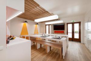帕尔梅拉Porta da Arrábida Suites的厨房铺有木地板,配有白色的桌子。