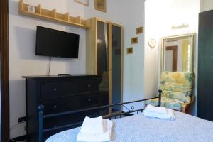 莱万托Fattore 8的一间卧室配有一张床、一台电视和一个梳妆台