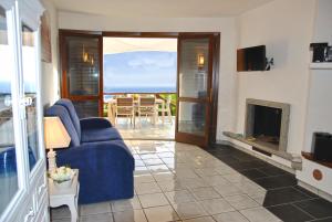 拉蒂纳VILLA ROMANTIC COVE vista mozzafiato sul mare的客厅设有蓝色的沙发和壁炉