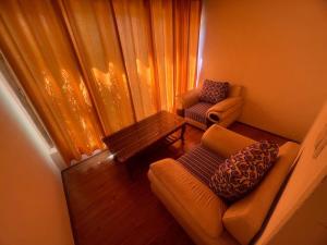 列城Guza Ethnic Resort的带沙发和桌子的小客厅